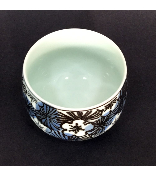 Bowl for tea with flowers of cherry in blue and black