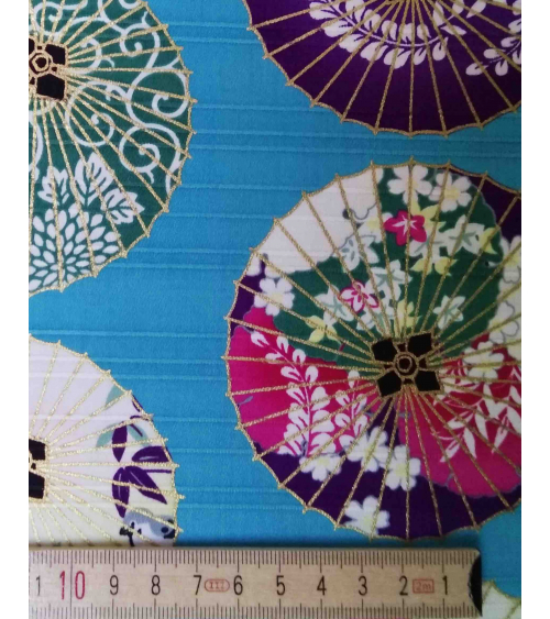 Cotton satin fabric. Paper umbrellas over turquoise-blue background.