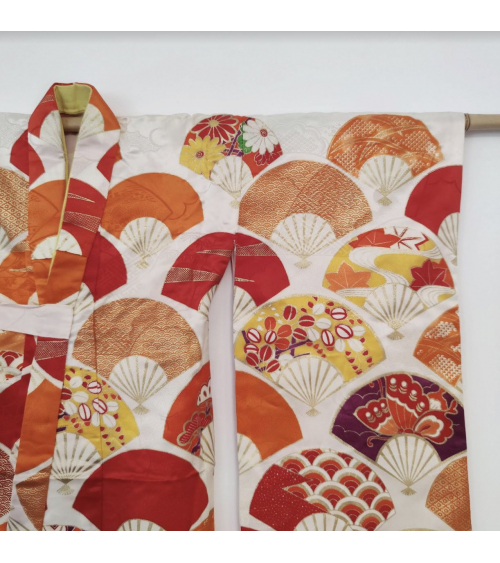 Girl's kimono with fans for sichi-go-san in orange tones.
