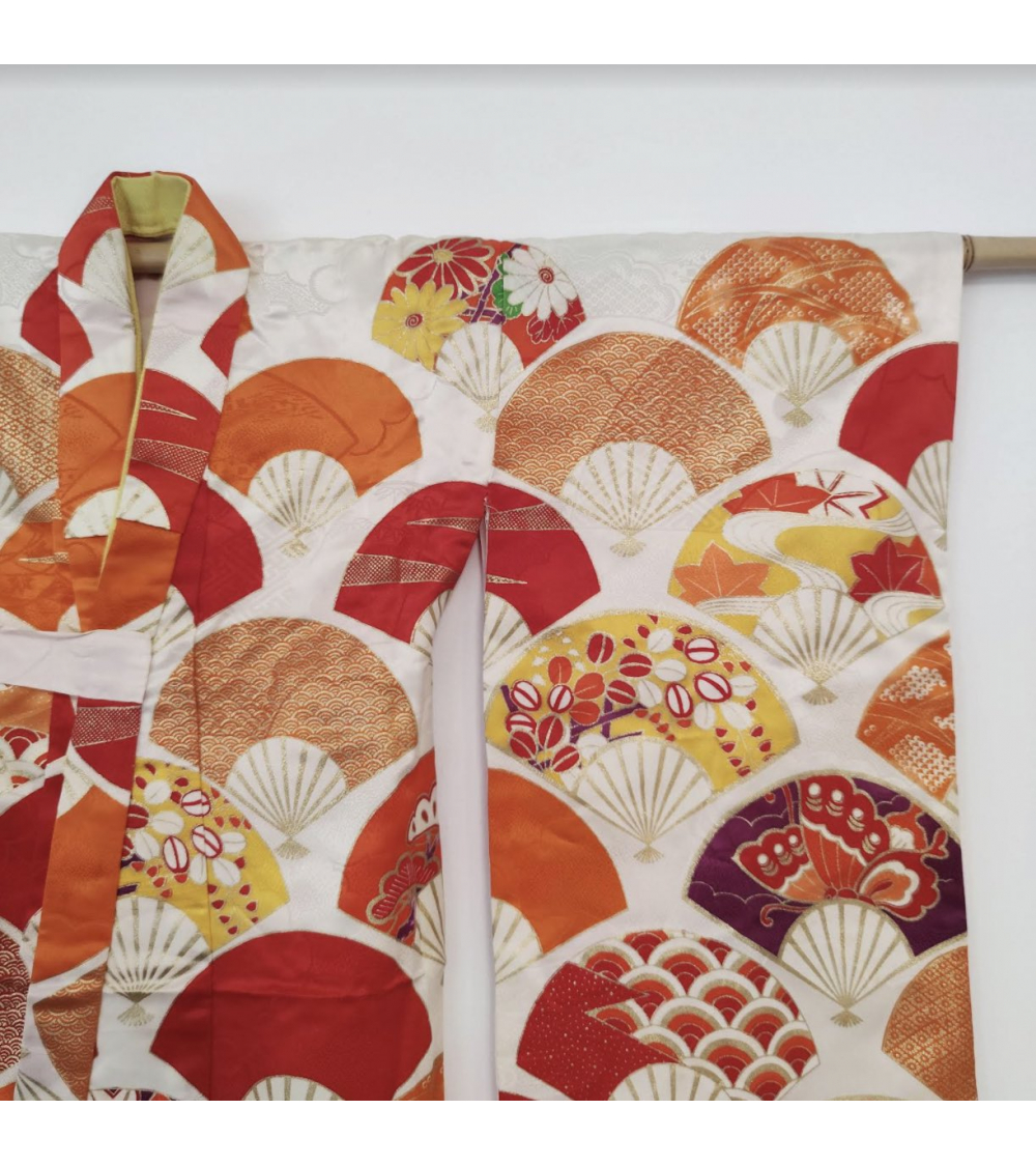 Girl's kimono with fans for sichi-go-san in orange hue.