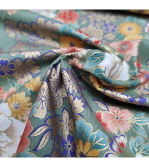 Japanese fabric with multicolor and golden flowers on green.