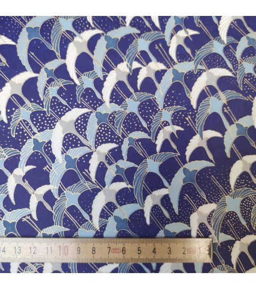 Japanese Chiyogami paper with flying cranes on a blue background.