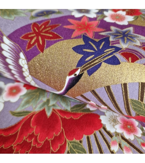 Tela japonesa. Grullas (tsuru) y flores (hana). Motivo multicolor y oro, sobre fondo lila.