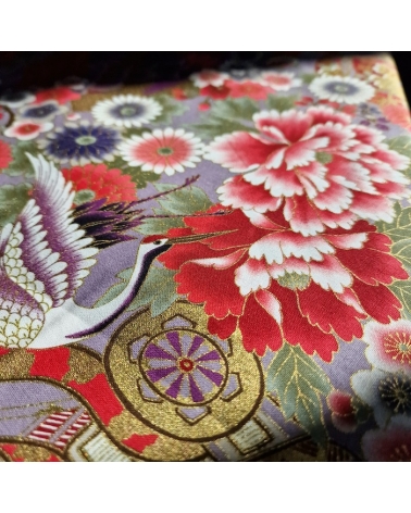 Japanese fabric. Multicolored cranes (tsuru) and flowers (hana) over lilac background, outlined in gold.