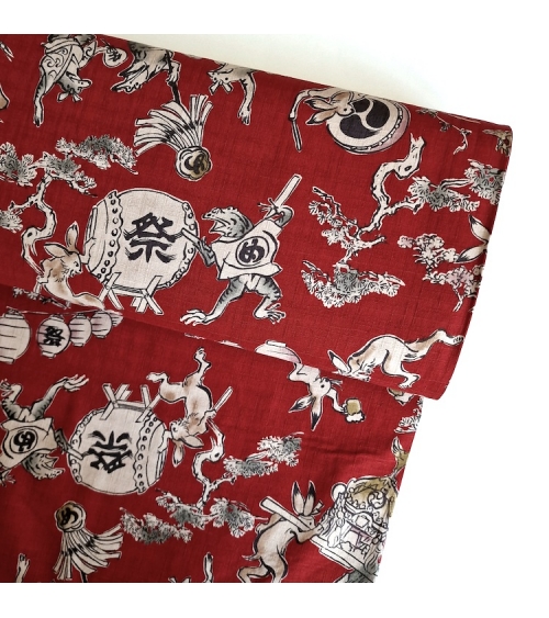Tela japonesa "Choju-giga" con fondo rojo guinda, en dobby de algodón 100%.